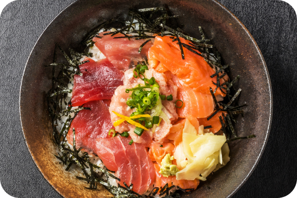 ご飯にマグロ、サーモン、ネギトロ、刻み海苔、薬味を盛り付けた海鮮丼