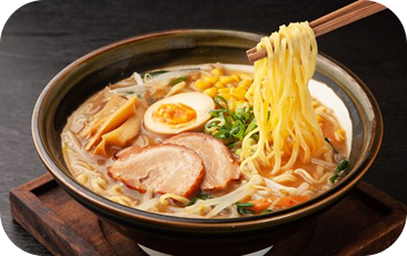 チャーシュー、味玉、コーン入りラーメンを箸で持ち上げる。