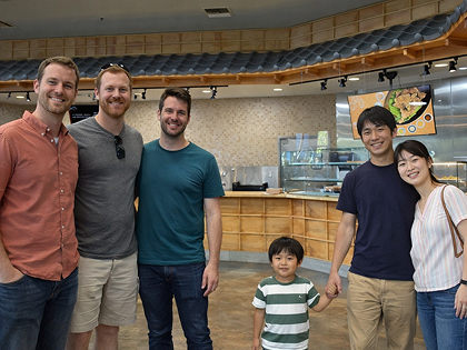 和風のカウンター式飲食店。メニューと開店祝いの花。