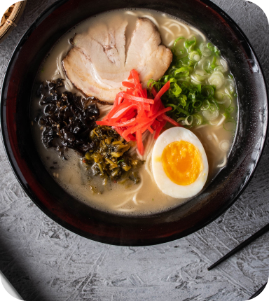 チャーシュー、卵、紅生姜、青ネギ、きくらげが乗った豚骨ラーメン